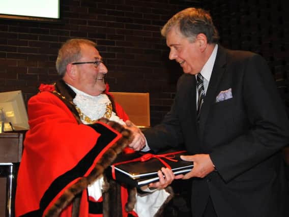 New Mayor Coun Alan Emerson presents predecessor Coun Barry Curran with a pictorial record of his year in office