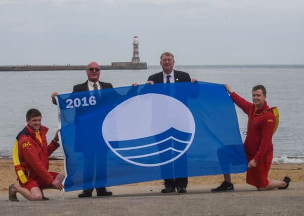 Lifeguards Phil Johnson, left, and Alexander Richardson with chairman of the Sunderland Seafront Traders Association, Tom Parkin, second left, and  Coun John Kelly holding the Blue Flag Award.