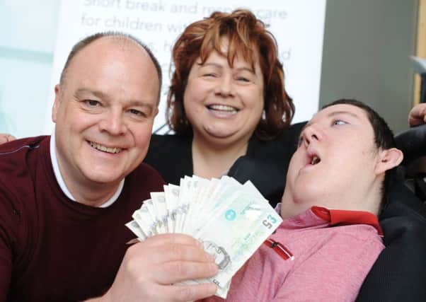 Grace House's Karen Maclennan, centre, and Christopher Lowden, receive Â£320 from runner Mark Wrightson, left, who took part in the Sunderland 10k.