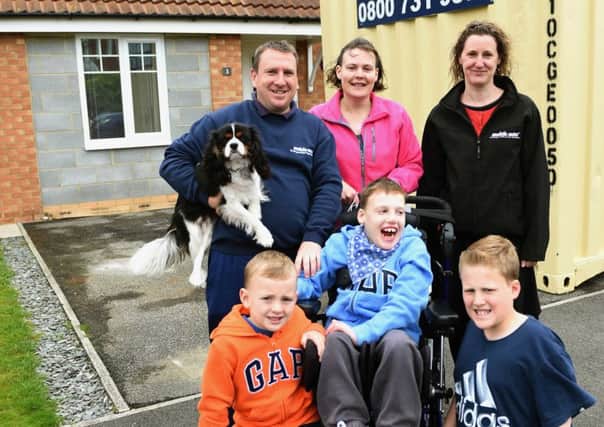 Keaton Oakes, centre, with his brothers Oliver and George (front) his dad Darren, his mum Romana and Zoe Brookes from Mobile Mini with family pet Oscar.
