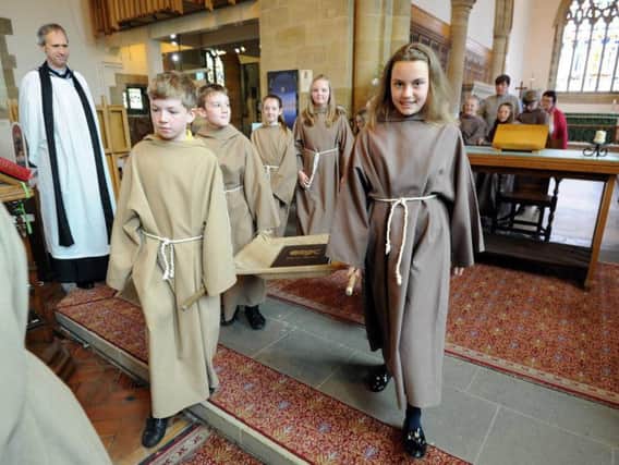 Pupils from Fulwell Primary School carry the Children's Codex out of St Peter's Church.