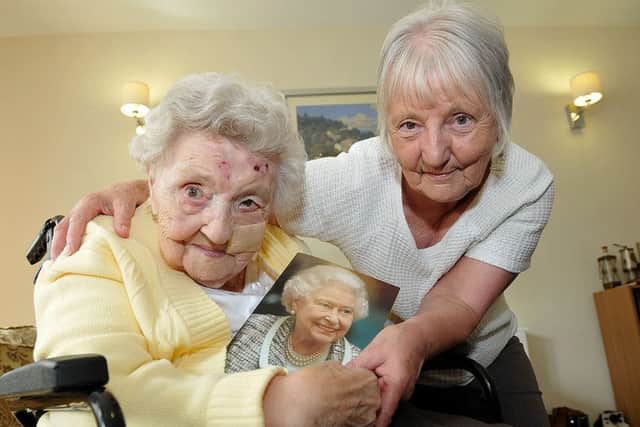 Sarah Jane Holst shows her birthday card from the Queen, with her daughter Audrey Page.