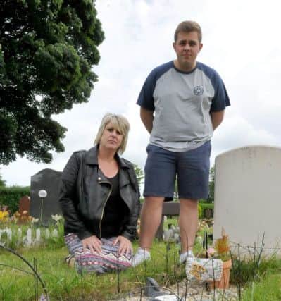 Julie Liddle with her son Aidan Canagan at the grave of her parents.