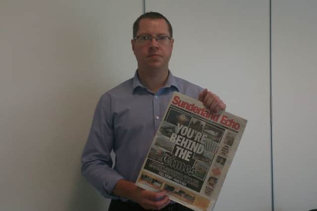 Gavin Foster holds up the Echo front page.