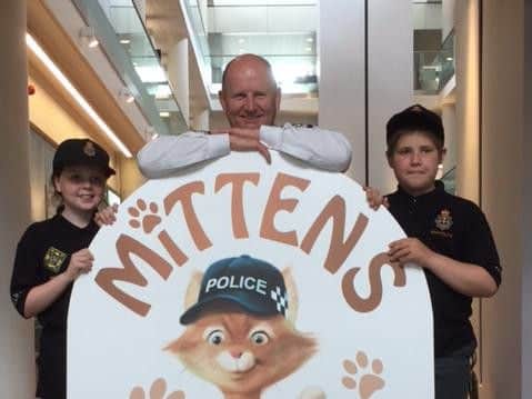 Chief Constable Mike Barton with two children from Ludworth Primary School and the artwork of Mittens the Kitten.
