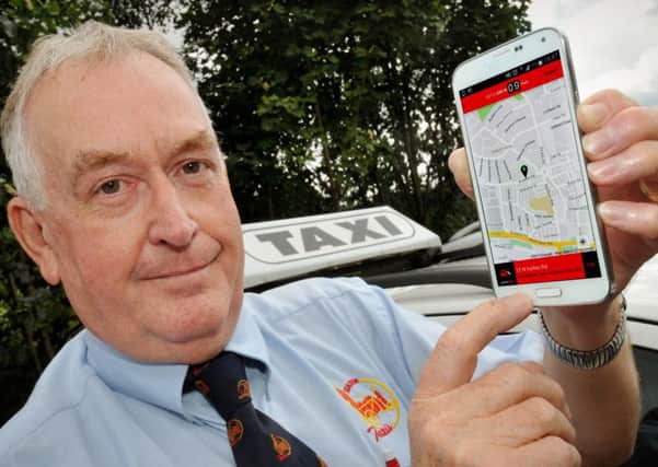 Managing director of Station Taxis, Trevor Hines, with the smartphone app run by his company.