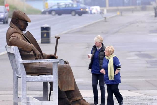 People taking a walk along Scarborough's North Bay stop to look at Freddie Gilroy, with many taking a seat alongside him as they take a breather and enjoy the view.