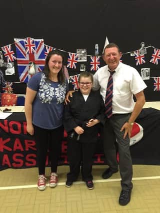 Belmont Karate Club student Karina pictured with her karate instructor Jane Clark and David Jenkinson, from the Northern Karate Association.