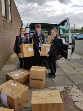 Beth Laybourne, head girl, Euan Parker, head boy and Niamh Dawson, deputy head girl, of Hetton School helping to load books for shipment to Africa as part of Book Aid Africa.