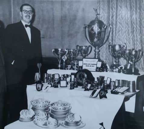 Alec Adamson with many of the trophies he won during his darts career.