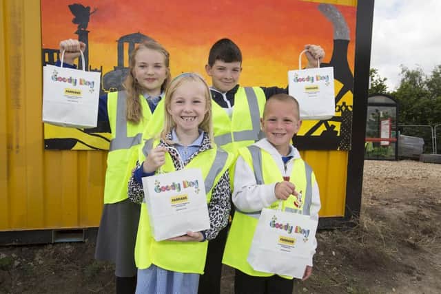 Pupils (back, from left) Holly Tait, Oliver Campbell, Sophie Davison-Pullan and Jay Hindmarsh are pictured with their FVB goody bags with the painting of the glowing Sunderland skyline in the background.