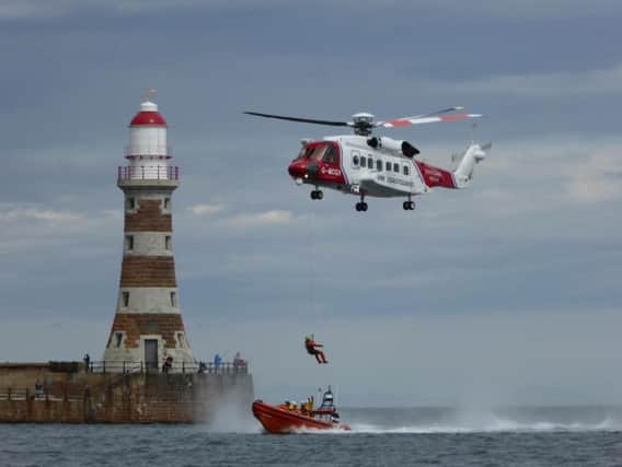 Volunteer crew members from Sunderland lifeboat station taking part in a search and rescue demonstration alongside a HM Coastguard helicopter as part of their annual harbour day activities. Picture by Paul Nicholson.