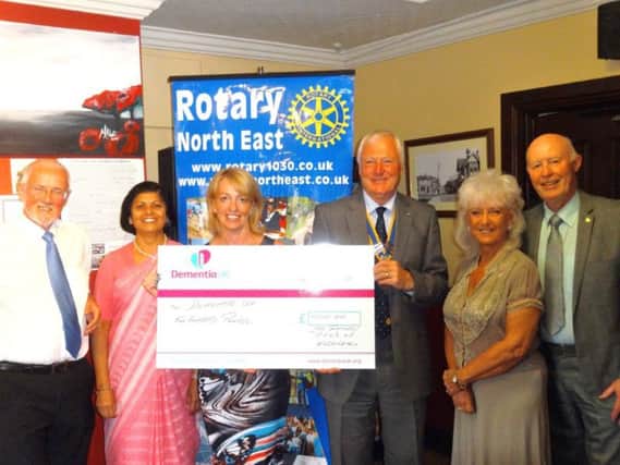 The Rotary Club of Washington President Keith Peacock presents Julie Allen, from Dementia UK North East, with a cheque, watched by fellow members.