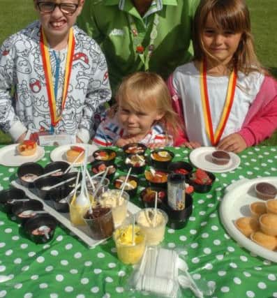 Tracy Tough from Asda Boldon on the cake decirating stall with cousins Logan Howard (8), Holly (3) and Poppy (6) Gibson Lillie at the Grace House Summer Fun Day at Wearmouth CW, Thompson Road, Sunderland.