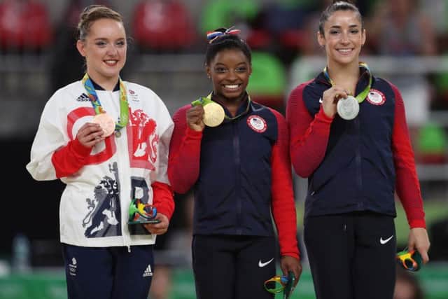 Great Britain's Amy Tinkler, left, celebrates a bronze medal with gold medallist Simone Biles and silver medallist Aly Raisman, right. Pic: PA.