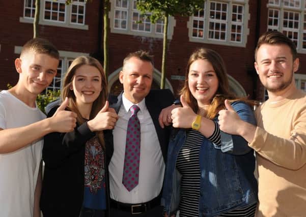 A Level students, left to right, Owen Underwood, Anna Walton, Emma McGory, and Michael Brigham, with college deputy principal Nigel Harrett, centre, collect their results from Sunderland College's Bede Campus.
