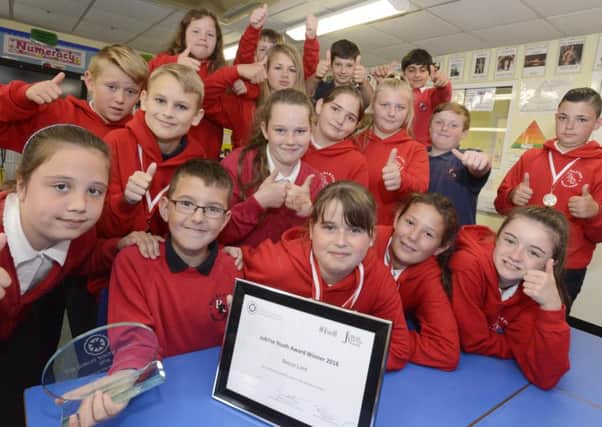 Reece Lunt with his Jubilee Award and his delighted classmates.
Picture by Jane Coltman