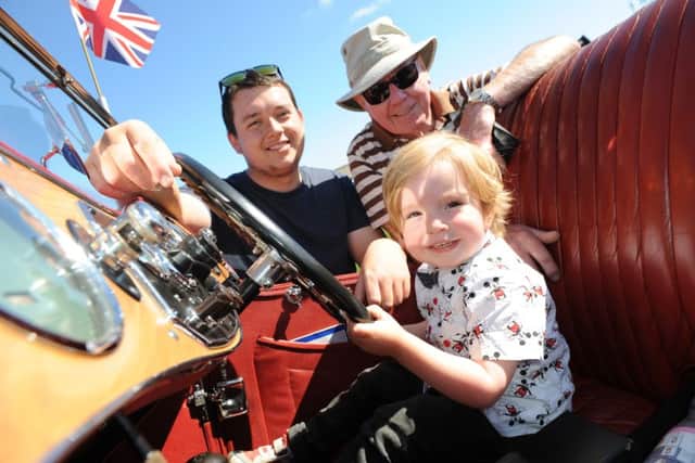Youngster Toby Clow take the wheel, watched by dad Sam and car owner Roy Kingan at the North East Bus Preservation Society's Vehicle Rally at Seaburn Recreation Ground, Sunderland.