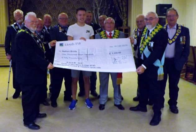 Nathan Brady receives a cheque from members of the Red House Community Centre RAOB - GLE, Â Pride of the Wear and members of Bear Park George Cunningham Lodges towards the cost of his travel expenses.