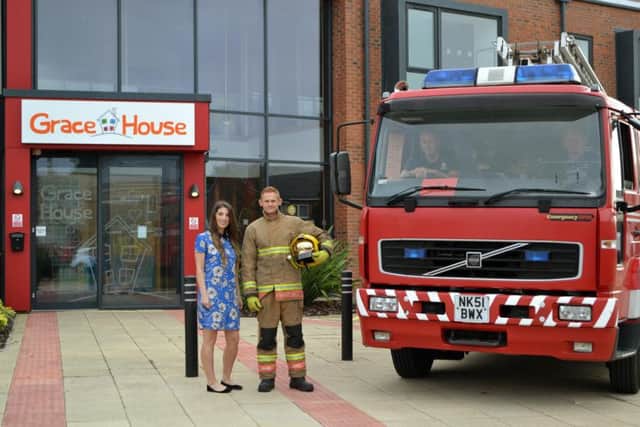 Grace House Business Development Manager, Jane Lertas-Robinson meet's Simon Johnson to discuss his GNR challenge, whilst fellow fire fighters show their support. Picture by Rebecca Ashby.