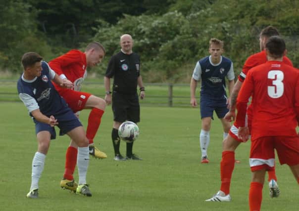 Washingtons Joe Walton (red) battles against Shildon in last week's FA Cup tie
