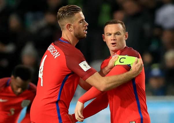 England's Wayne Rooney receives the captain's armband from Jordan Henderson after coming on as a subtitute during the World Cup Qualifying match at the Stozice Stadium in Ljubljana.
