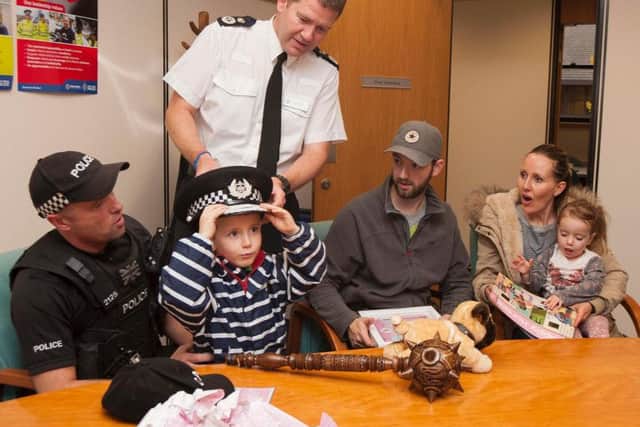 Nicole's brother Louis tries on a hat for size during the police HQ visit.
