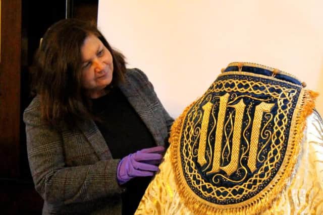 LIsa Di Tommaso with one of the coronation capes featured in the exhibition