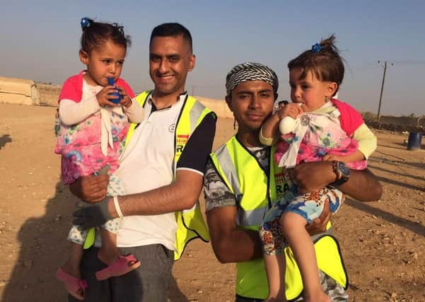 Taz Maqsood and Monir Ahmed with twins during their trip to the Jordan camps which are helping people flee Syria.