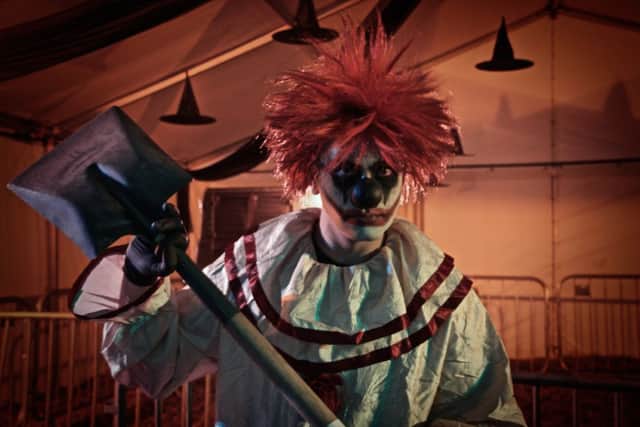 A clown prepares to 'welcome' the crowds as Scream Factory opens for th evening.