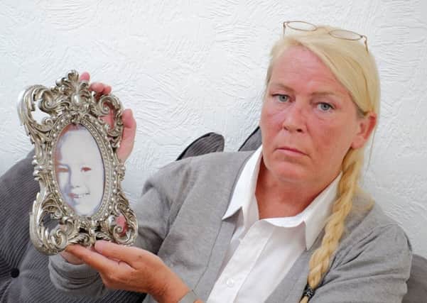 Sharon Henderson, with a photo of her murdered daughter Nikki Allan.