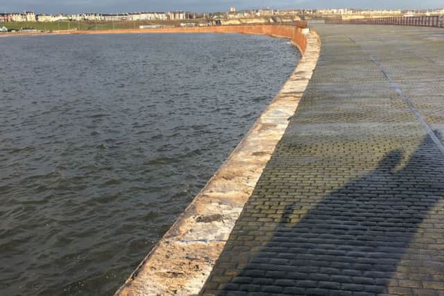 A section of Roker Pier where railings have been washed away by stormy seas.