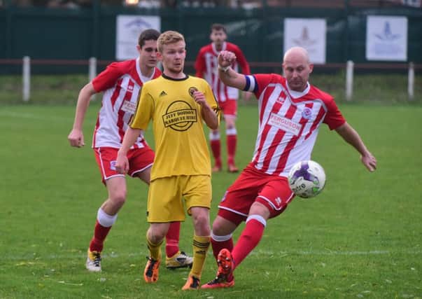 Lee Kerr of Seaham Red Star (red/white) takes on West Auckland. Picture by Kevin Brady