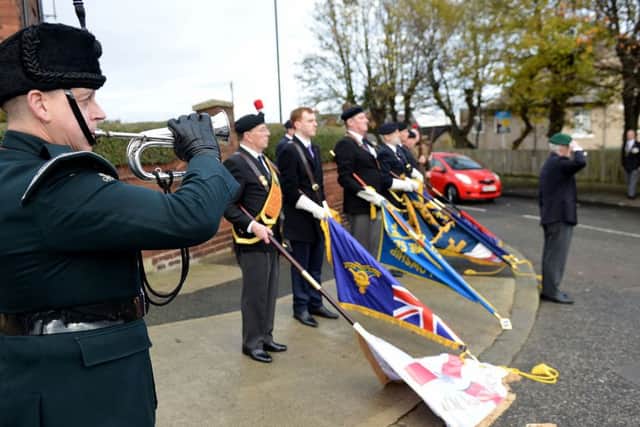 The standards are lowered as the Burgler plays the Last Post at the end of  the blue plaque unveiling in honour of Wing Commander Claude Ridley,.  Picture by FRANK REID