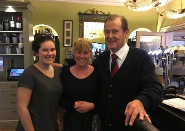 Sir Roger Moore with staff from Three Horseshoes on a visit to the area in November 2016.
