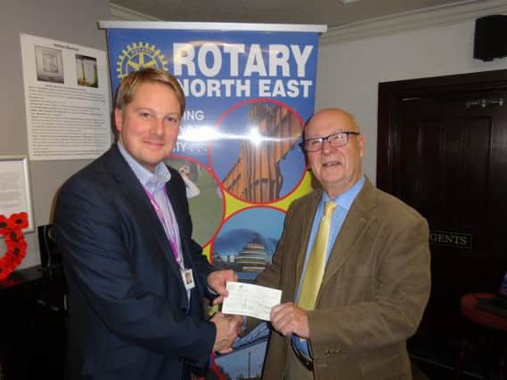 Bob Chilton, stand-in for Rotary Club of Washington's president, presents Michael the Rainbow Trust's Lavery with the club's cheque.