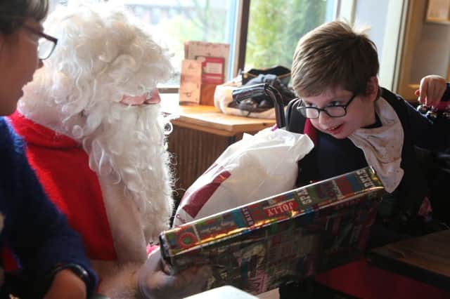 Santa gives a present to Katie Cruddas at the Grace House Christmas party in Libert Browns, Sunderland. Picture: TOM BANKS