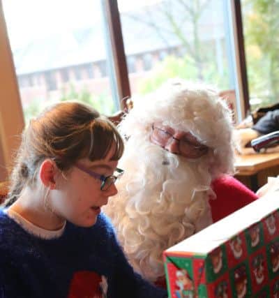 Santa gives a present to Jasmine Ather at the Grace House Christmas party in Libert Browns, Sunderland. Picture: TOM BANKS