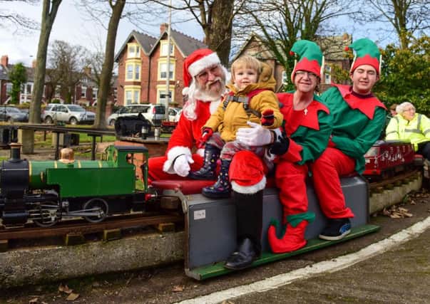 Miles Anstay, two, with Santa and his helpers on the City of Sunderland Model Engineering Society's model train in Roker Park.