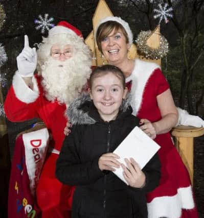 Student Chelsie Frew, 12, is all smiles after receiving a gift from Santa and Mrs Claus.