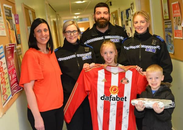 Elise Burnning receives signed a Sunderland AFC shirt after her bike was stolen. From left mother Lisa Brunning, PCSO Aimee Guest, Pc John Bowman, PCSO Linzi Graham and brother Zak Brunning, five.