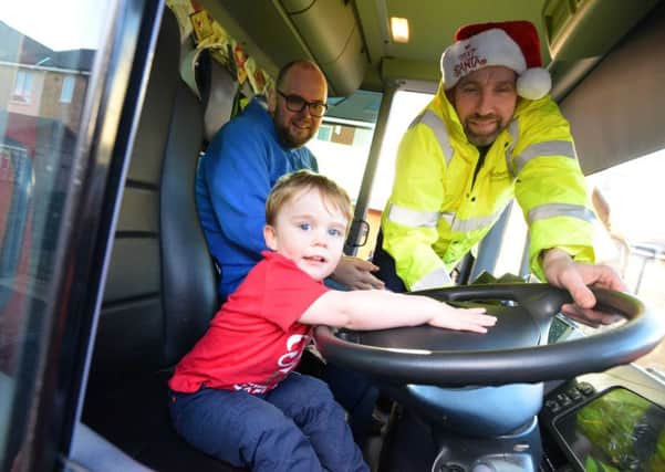 Toddler Zach Roper, 2 receives Christmas gifts from Sunderland's City Council binmen. 
Father Michael Roper and binman Mark Brown