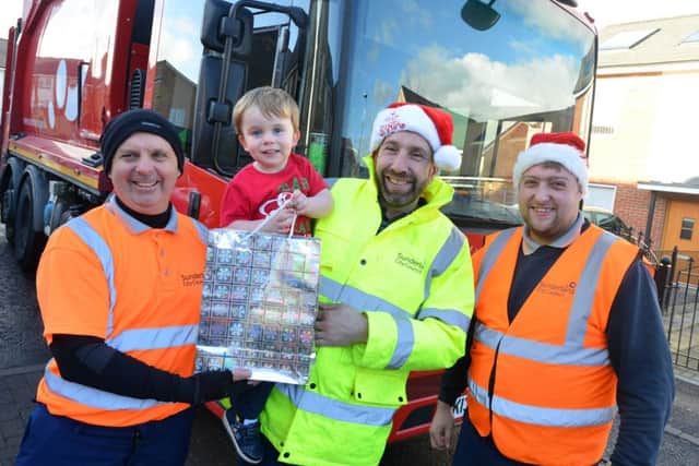 Toddler Zach Roper, 2 receives Christmas gifts from Sunderland's City Council binmen. 
Binmen from left Kevin Hodgson, Mark Brown and Steven Kenny