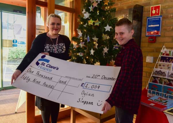 Dylan Simpson handed over a cheque for Â£1,059 to Tyler Anderson of St Clares Hospice