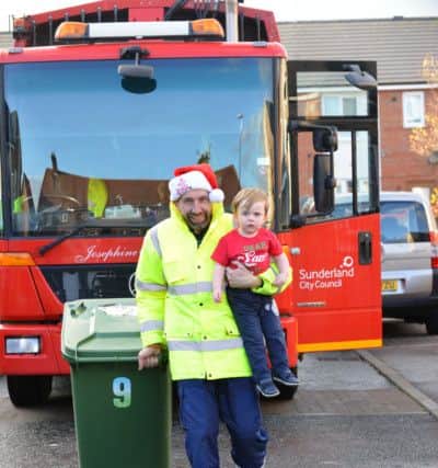 Toddler Zach Roper, 2 receives Christmas gifts from Sunderland's City Council binmen. 
Binman Mark Brown