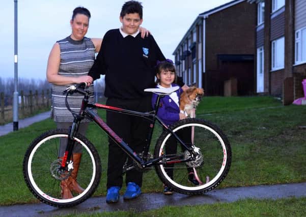 Tyler Woodward, 14 with his donated replacement bike after his Christmas bike was stolen. Pictured with mother Lucy Jackson and sister Kodee-Mae Jackson, 4, with dog Bella.