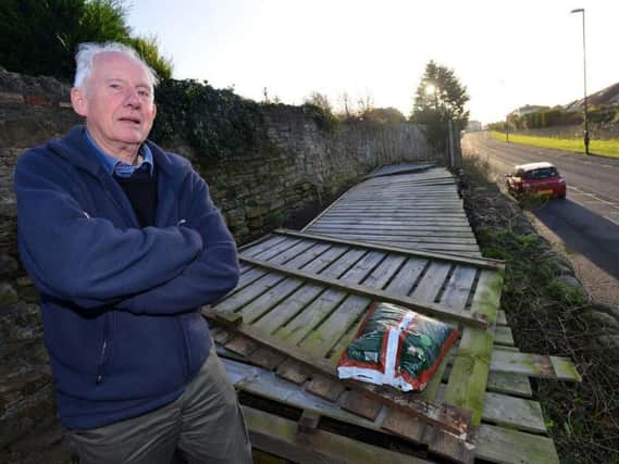 Ken Embleton with the fence which was pulled down with the help of the fire service.