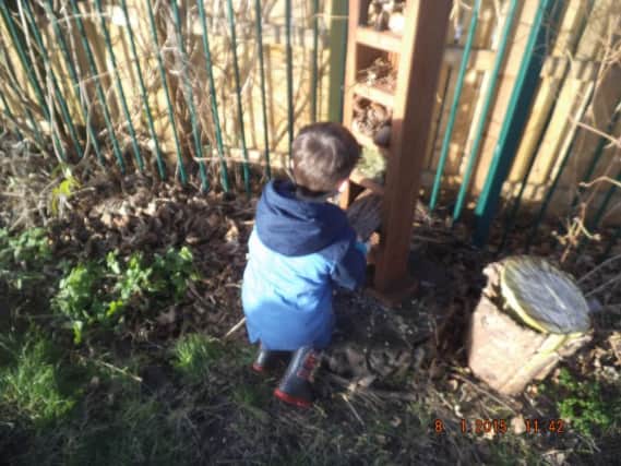 A Helen Gibson Nursery school pupil enjoys an outdoor activity in the garden.