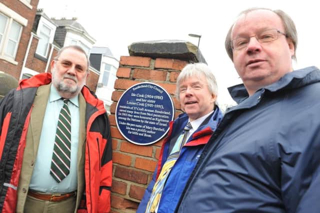 The nephews of Ida and Louise Cook, John, Peter and Rolf, gather around the plaque.