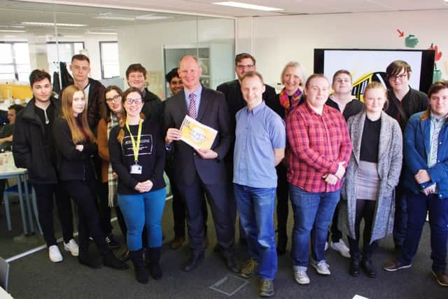Huw Lewis, corporate manager for customer services and communications at Nexus, centre, with college staff and students